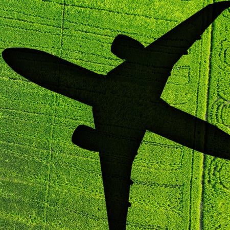 Plane over green field